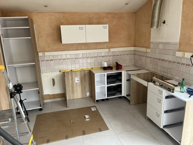 Premiers meubles de la cuisine blanche et bois en cours de pose